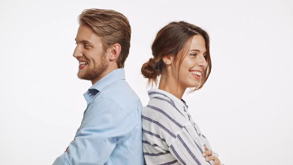 Beautiful Caucasian Pair Standing Back to Back Flirtring Laughing on White Background in Slowmotion