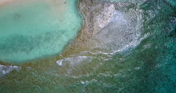 Luxury fly over clean view of a sandy white paradise beach and aqua turquoise water background