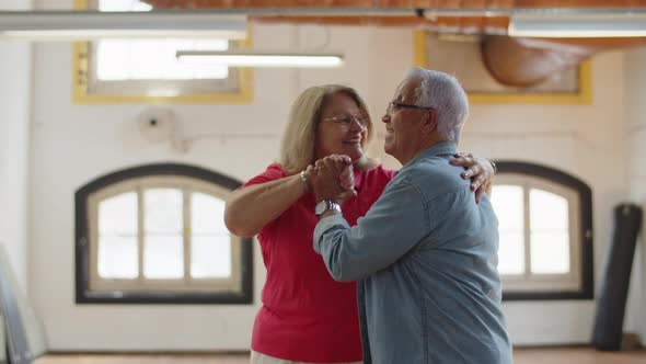 Medium Shot of Happy Senior Couple Dancing Together in Ballroom