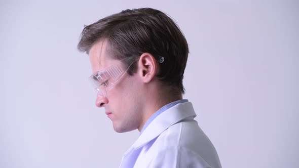 Profile View of Young Handsome Man Doctor Wearing Protective Glasses and Looking Up