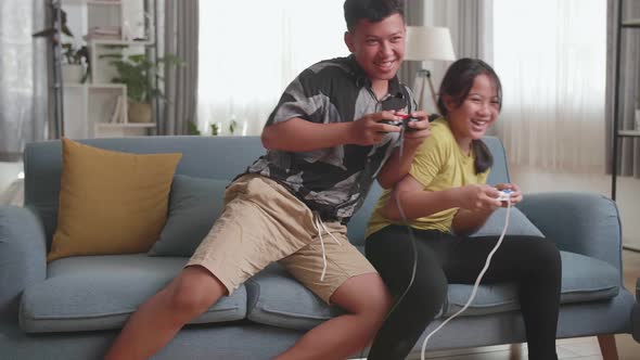 Funny Asian Children With Joystick Game Playing Video Games On Tv At Home