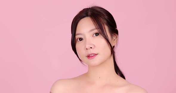 Close up of young beautiful Asian woman on pink background.