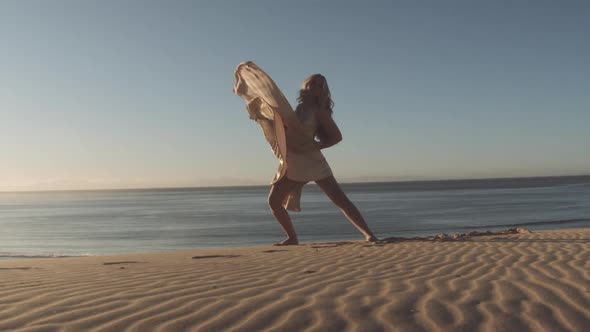 Woman In Golden Dress Dancing On Sandy Beach