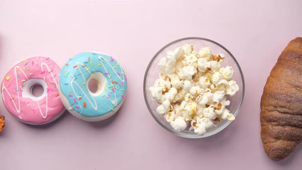 Slice of Cheese Pizza on a Plate  Donuts and Popcorn on Pink