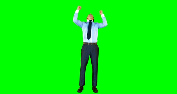 Excited businessman standing against green background