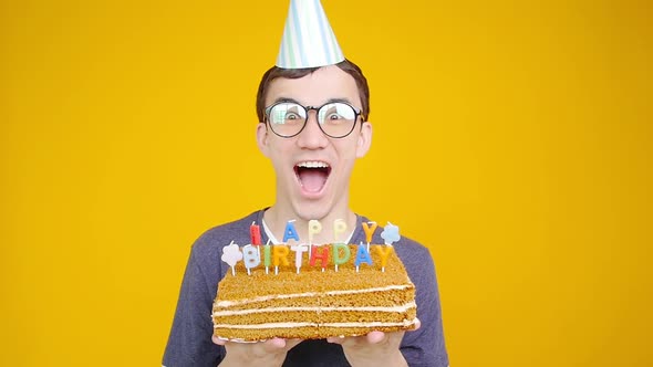 Happy Birthday Concept. Young Funny Man with a Cake o an Orange Background