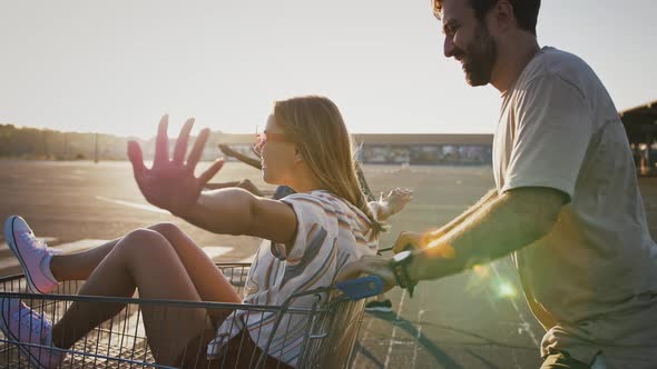 Friends Racing on Shopping Carts with Girlfriends at Deserted Car Parking