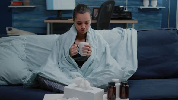 Person with Seasonal Flu Wrapped in Blanket on Couch