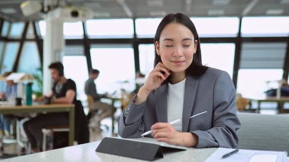 Young Professional Asian Business Woman Using Tablet Working in Big Office