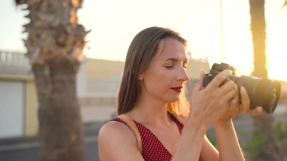 Photographer Tourist Woman Taking Photos with Camera in a Beautiful Tropical Landscape at Sunset