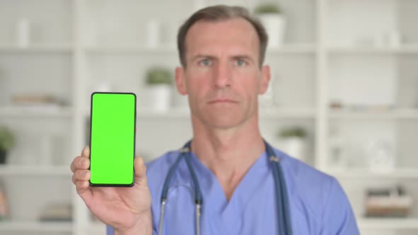 Portrait of Middle Age Doctor Holding Smartphone with Chroma Screen 