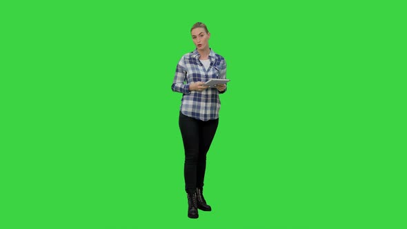 Young Woman Using Reading Presentation From a Tablet on a Green Screen, Chroma Key