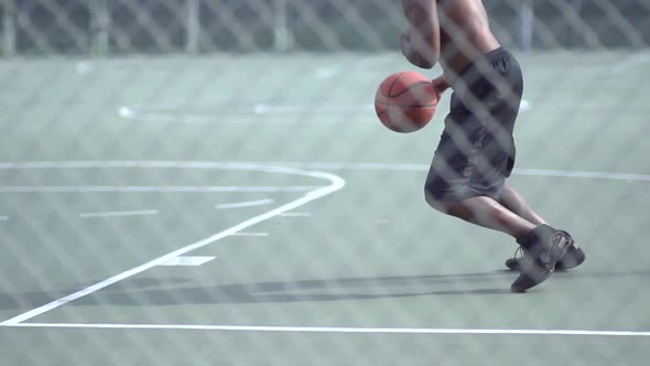 A young man playing basketball on a rainy day.