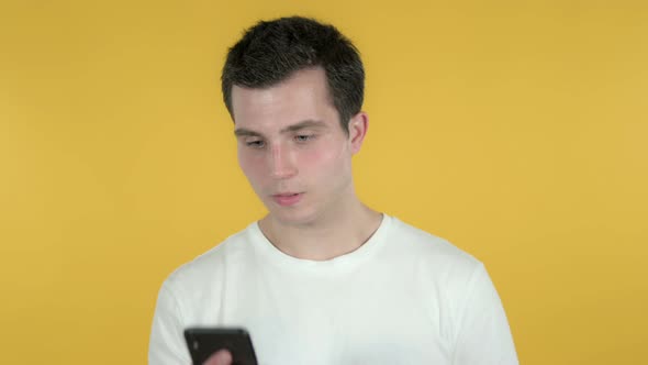 Man Talking on Smartphone, Yellow Background