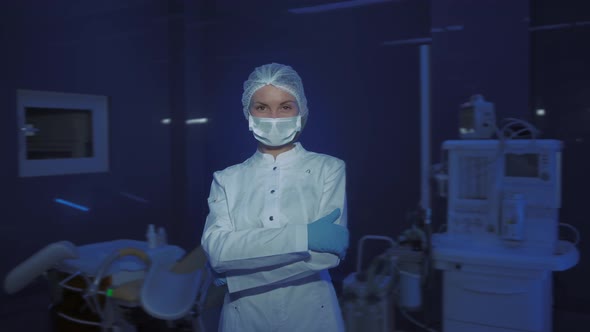 Portrait of Young Female Doctor in Medical Mask Looking at Camera