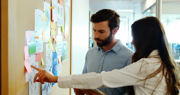 Business colleagues discussing over sticky notes