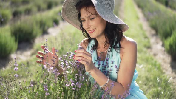 Happy Woman Smelling Lavender Flowers in Slow Motion Looking Away Smiling