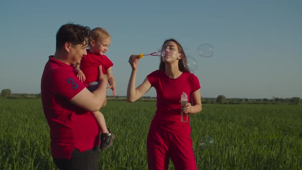Excited Family with Child Blowing Soap Bubbles