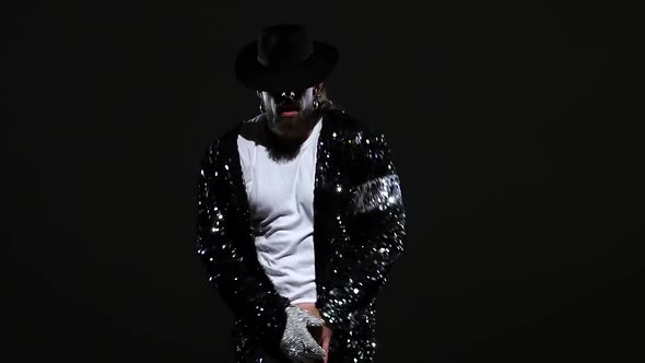 Young Stylish Man Dancing in Style Michael Jackson, Spotlight on a Black Background