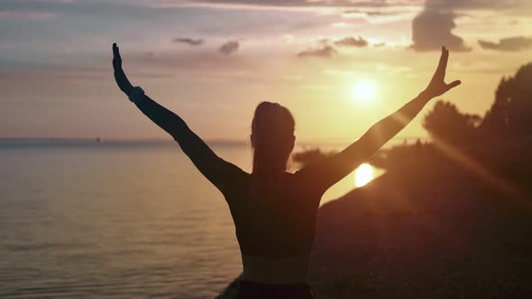 Back View Woman Practicing Yoga on Beach Admiring Evening Sun