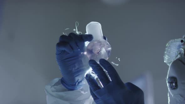 Chemist Looking at Vapor Coming out of Flask alt