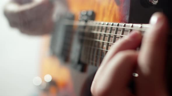 Male Musician Plays an Electric Guitar with Plectrum in Studio Closeup Hands