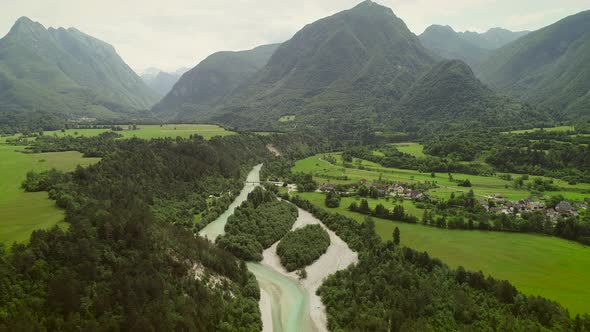 Aerial view of a small village with typical houses next to Soca river, Slovenia.