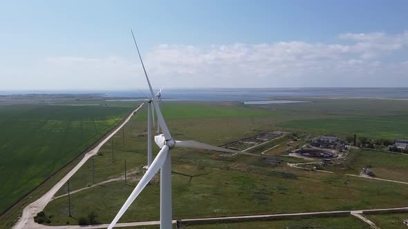 Drone footage of wind power pland and landscape with sea