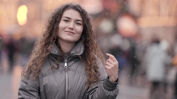 Portrait of a Young Woman with Curly Hair Posing on a City Street Wearing a Jacket Cold Season