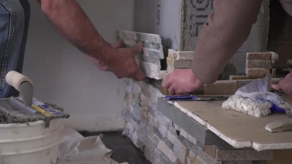 Male Hands Setting Stacked Stone Tiles for a Fireplace