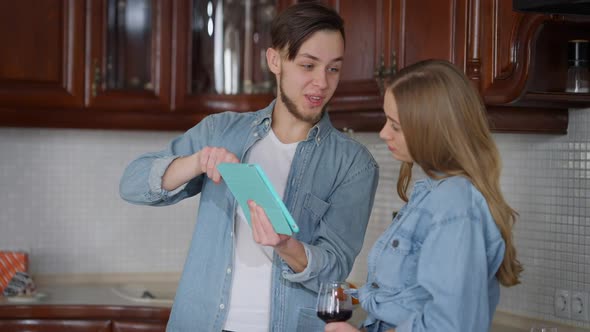 Young Joyful Couple Planning Redecoration in New Apartment