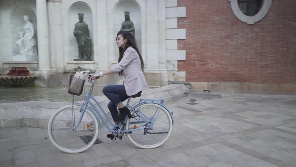 Moroccan Woman With Long Black Curly Hair Riding A Bike At The Park