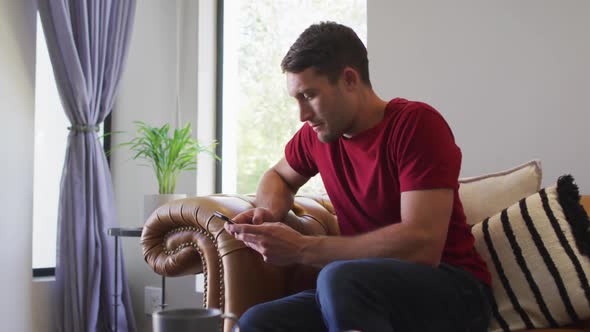 Caucasian man spending time at home and using smartphone