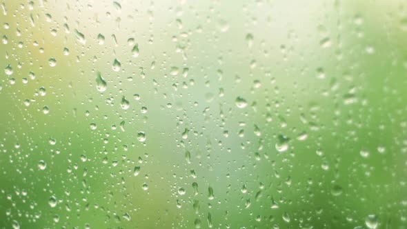 Heavy rainfall. Raindrops on a window pane on a summer day