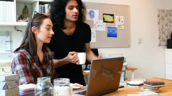 Executives discussing over laptop