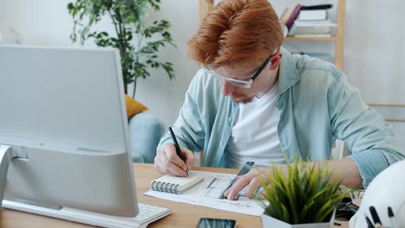 Portrait of Male Architect Designing Construction Plan on Paper and Using Computer in Apartment