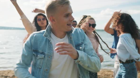 Slow Motion of Handsome Blond Man Dancing with Friends at Open Air Beach Party