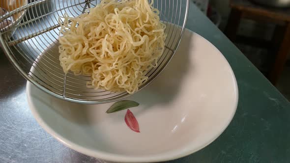 Close-up Footage of Chef Cooking Egg Noodles in a Bowl