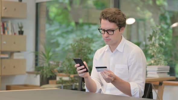 Young Man Making Online Payment on Smartphone