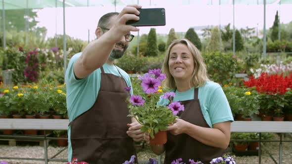 Happy Gardener Colleagues Using Mobile Phone at Work