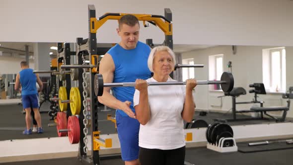 Elderly Woman is Engaged in a Sport in the Gym