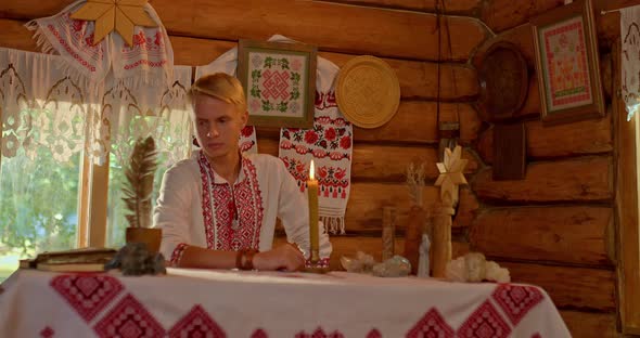 Portrait a Man in a Folk Costume Sits at a Table in a Russian Hut