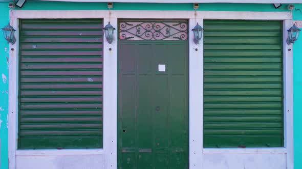 Facade of Blue House with Green Forged Door and Shutters