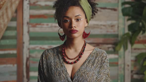 Young African American Woman Wearing Ethno Clothes with Authentic Accessories Turning Face to Camera