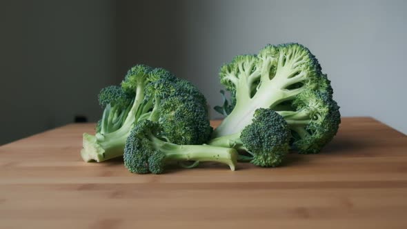 Bright and Fresh, Slow Push-in to Sliced Raw Broccoli on Light Wooden Tabletop