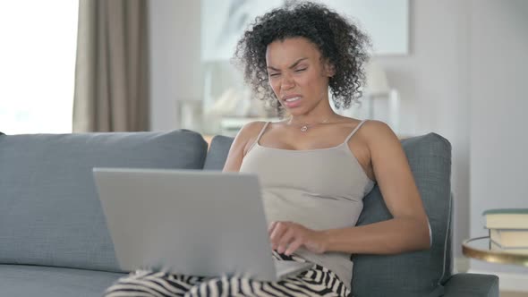 Tired African Woman with Laptop Having Back Pain at Home