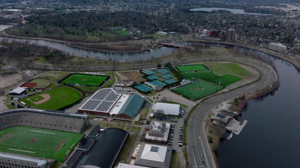 Aerial Panoramic View of Multilane Road Winding on Charles River Waterfront Around Sports Area