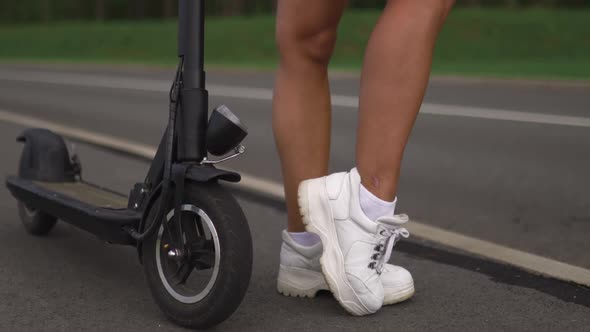 Pan Up Sexy Woman Posing Near Electric Scooter