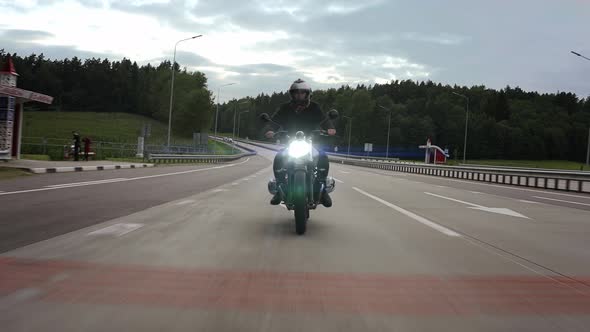 Man Riding Scrambler Motorbike on the Highway Through the Forest Front View