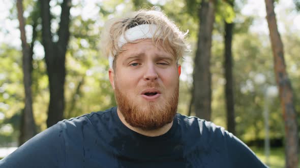 Portrait of Exhausted Obese Man after Run in Park